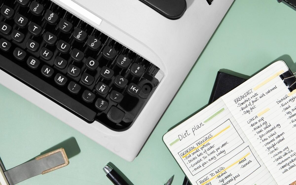 photo d'une machine a écrire et d'un cahier d'écriture